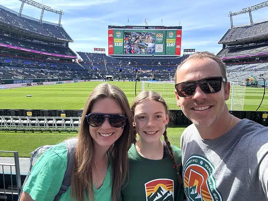 Mighty Pine owner and family posing on the field at Empower Field before a Denver Summit FC match in Denver, CO