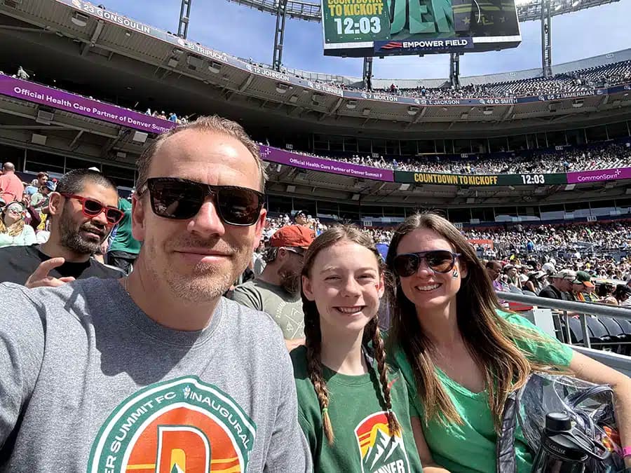 Mighty Pine owner and family cheering in the stands at a packed Denver Summit FC inaugural season game at Empower Field