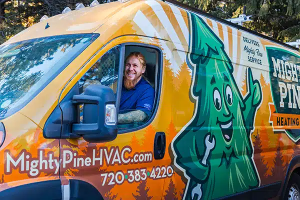 Mighty Pine service truck with a smiling technician driving.