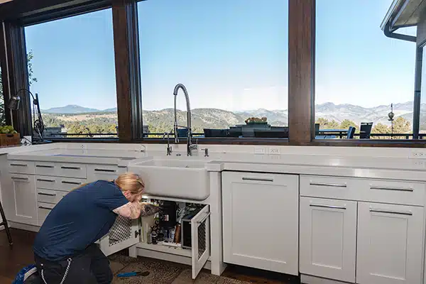Mighty Pine technician installing a garbage disposal in a home in Arvada, CO