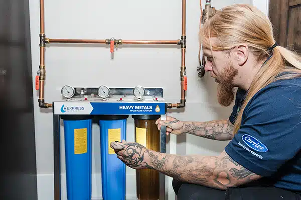 Mighty Pine technician installing a whole house filtration system in a residence in Arvada, CO