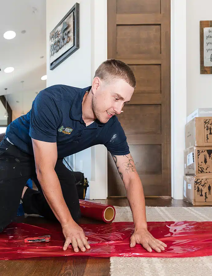 Mighty Pine technician laying down floor covering in a home in Arvada, CO