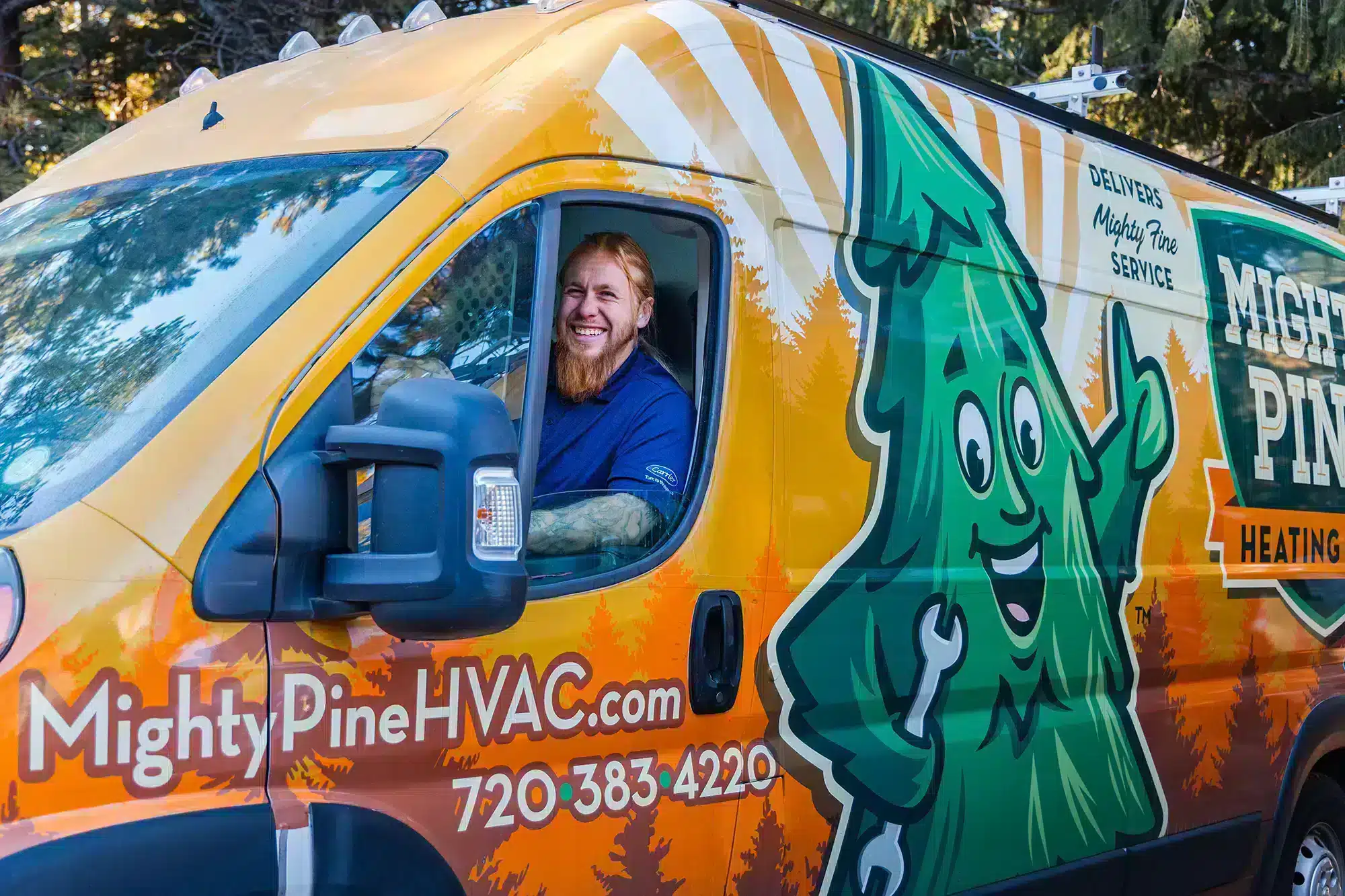 Mighty Pine service truck with a smiling technician driving.