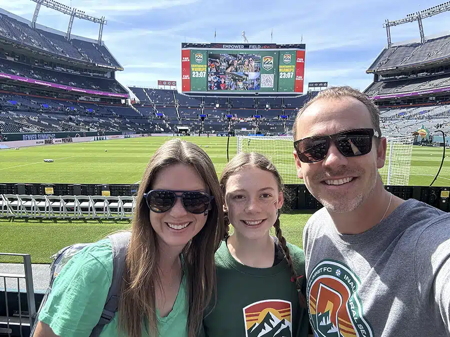 Mighty Pine owner and family posing on the field at Empower Field before a Denver Summit FC match in Denver, CO