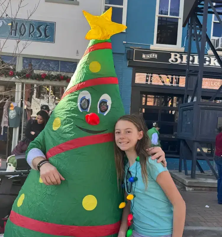 Mighty Pine the Christmas Tree with a happy kid.