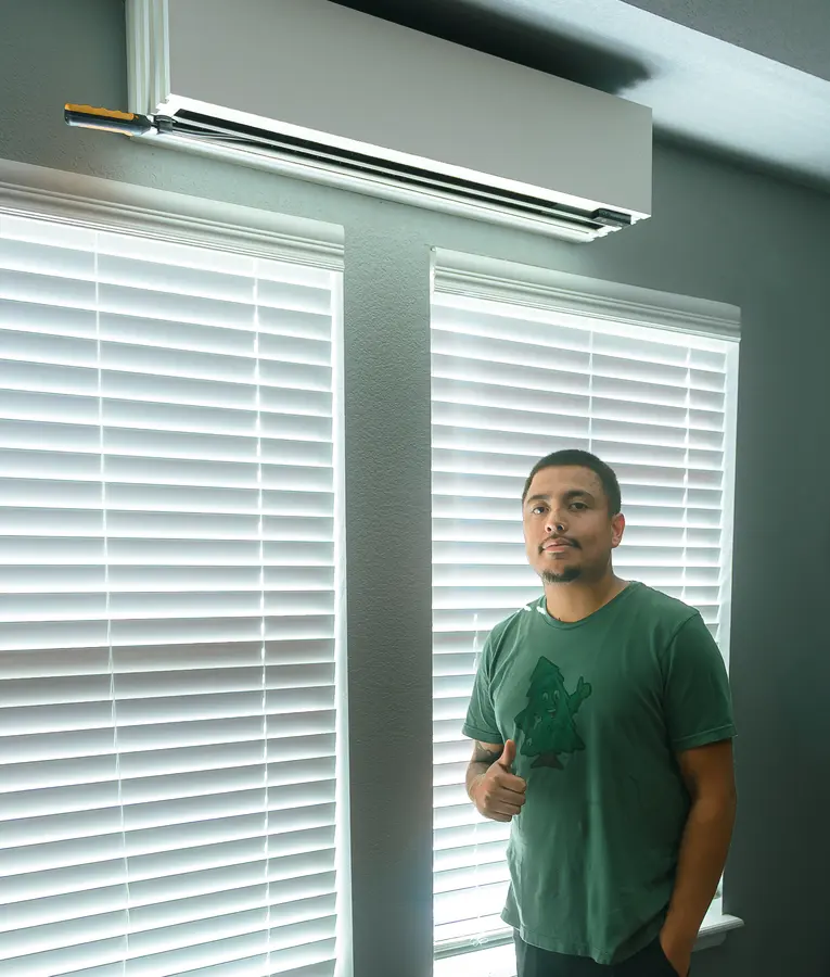 Mighty Pine technician next to a ductless mini split in an Arvada, CO home