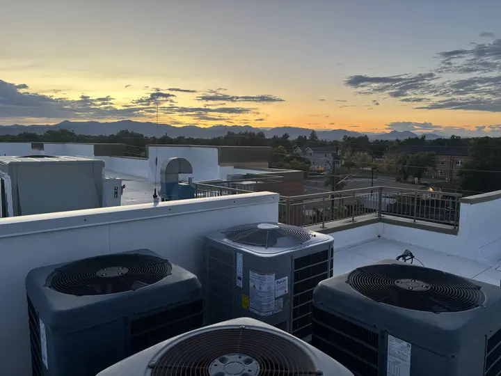 Air conditioning condensers installed on a rooftop by Mighty Pine