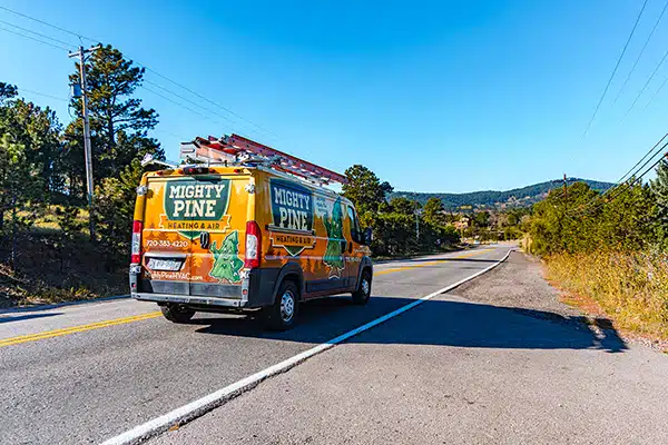 Mighty Pine service truck driving through the Colorado foothills.