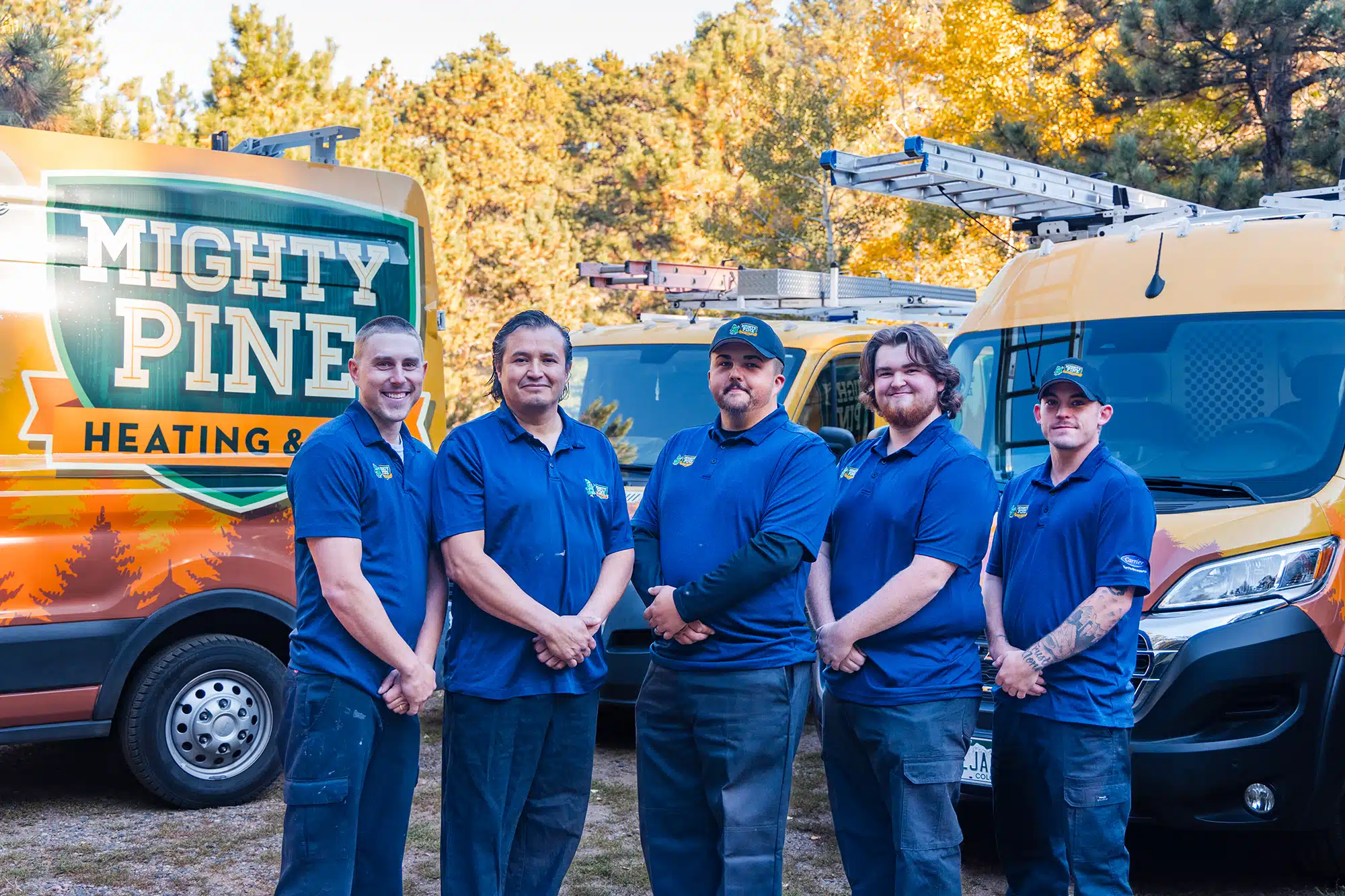 The Mighty Pine Service Team in front of the fleet of trucks.