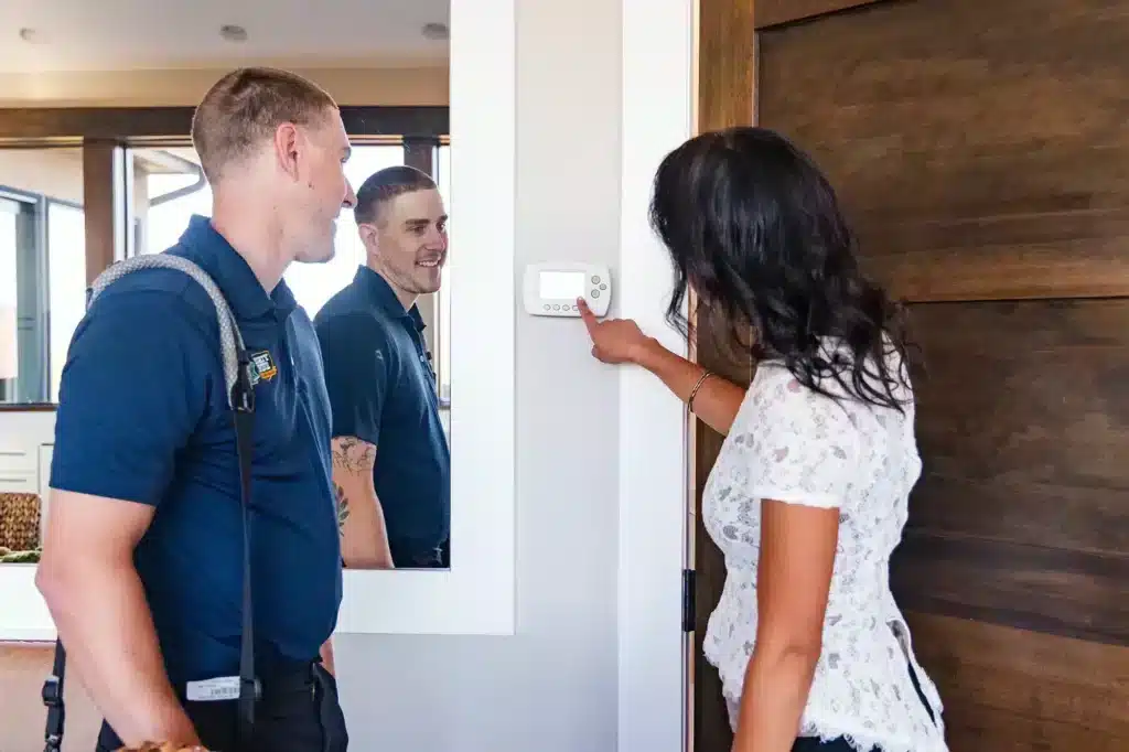 Mighty Pine technician helping a customer in Arvada, CO with their thermostat.