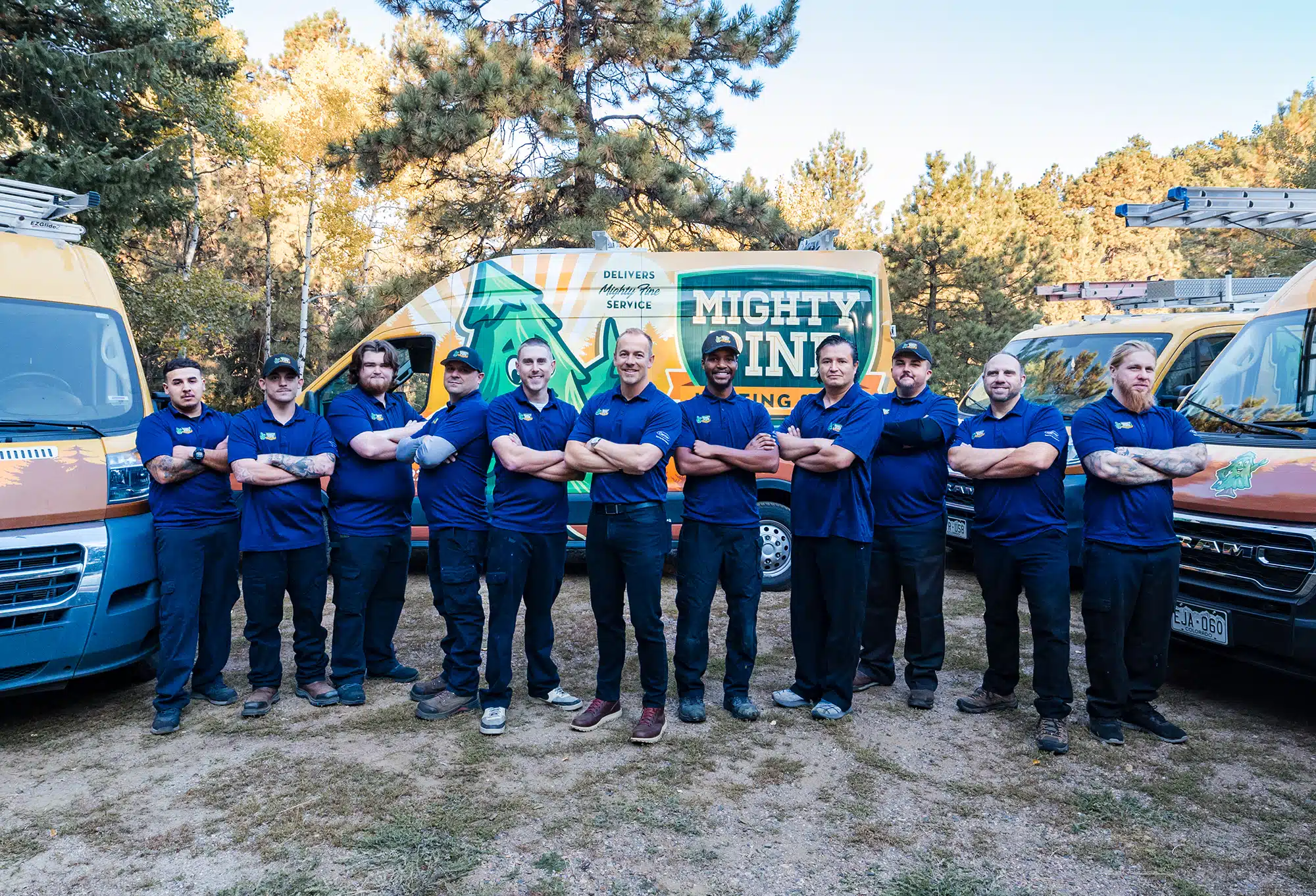 The owner of Mighty Pine, Judd Robertson, and the service team standing in front of their fleet of trucks.