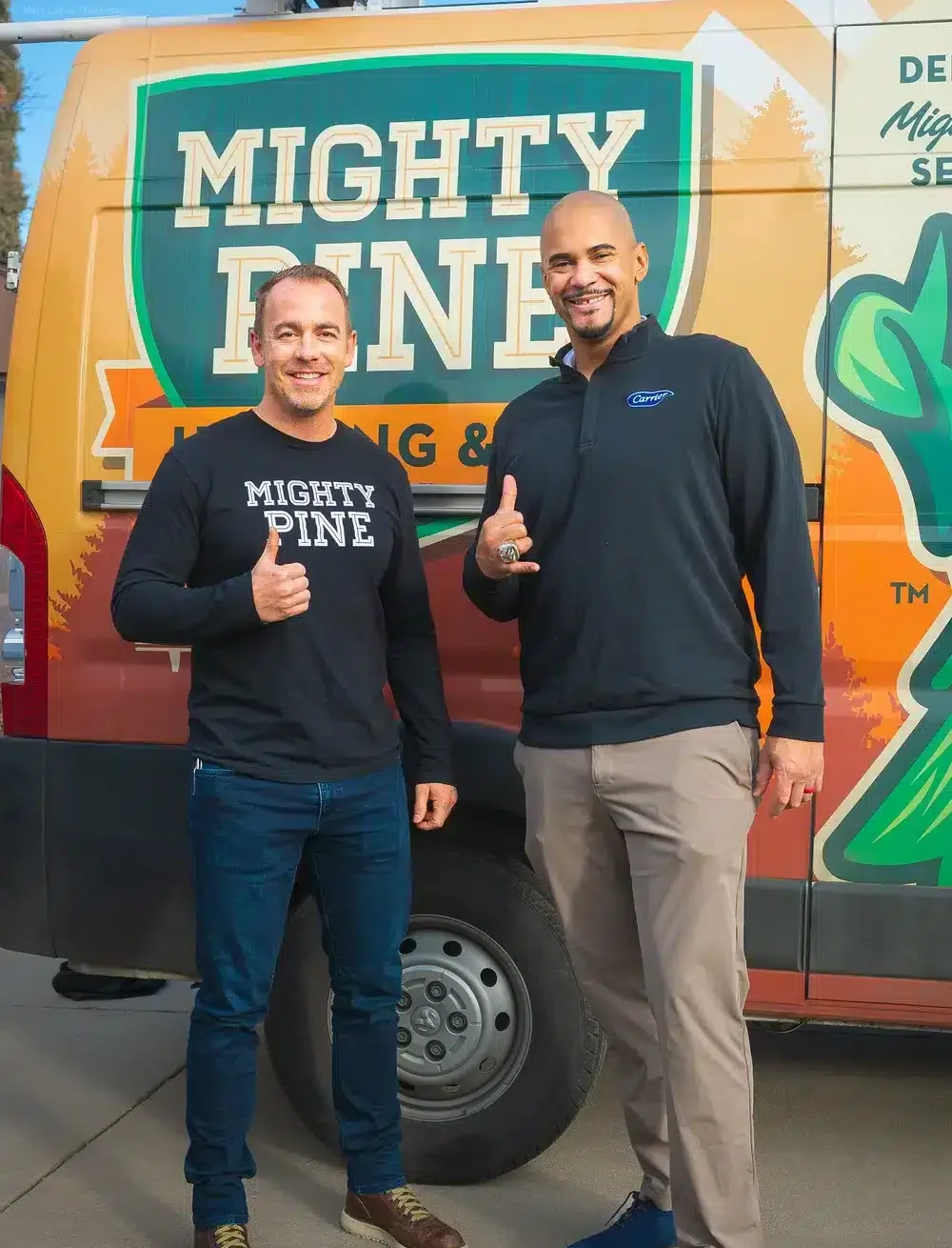 Technician with happy customer standing in front of mighty pine truck